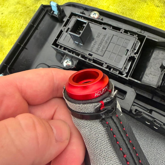 A close-up shot of the underside of the shift boot collar, where a zip tie holds the shift boot in place, joining the Gabafied Racing shift boot collar insert with the Acuity Shift boot collar SKU: 1924-K4